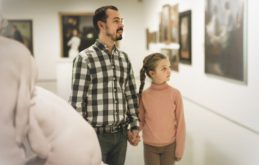 Smiling father and daughter exploring art