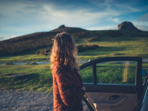 Woman opening car door in wilderness
