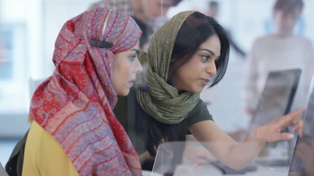 Mixed ethnicity telesales team working together in busy call center