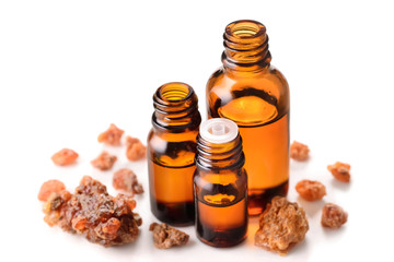 Myrrh essential oil in the amber bottle isolated on white