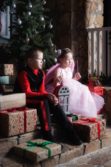 Obraz premium Boy and girl are sitting on the porch with gifts