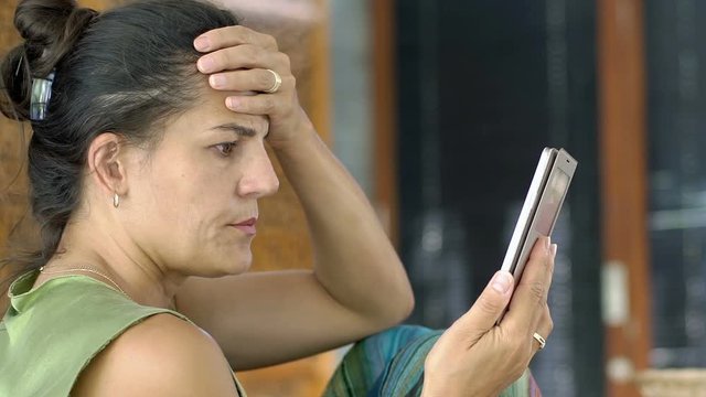 Woman checking smartphone in the dining room and looks very worried

