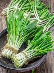 Young fresh wild garlic on the wooden table.