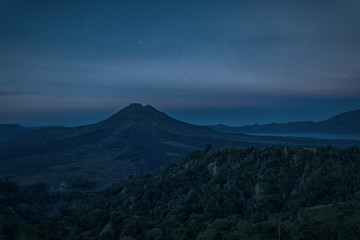 Silhouette of the mountain volcano Batur on background night sky with stars © glass_frog
