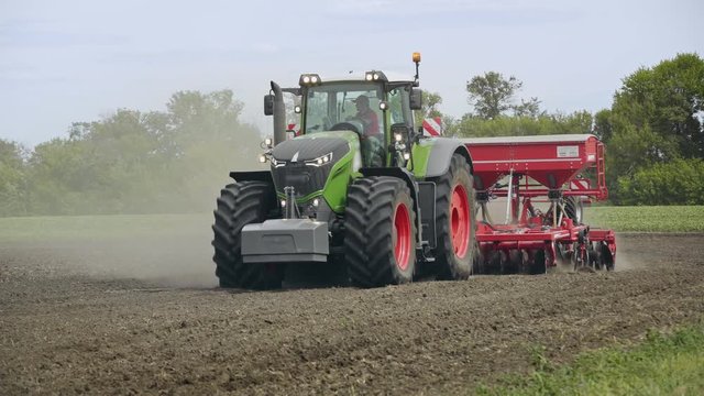 Tractor And Field. Farm Tractor With Trailer Seeder Making Sowing Agricultural Field. Process Sowing Plowed Field. Agricultural Machinery Working On Farming Field. Agriculture Equipment