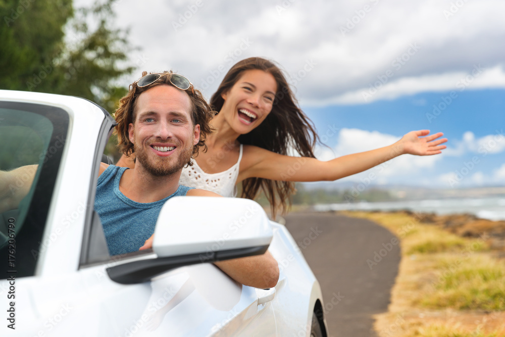 Wall mural car road trip couple summer fun on travel vacation freedom. happy free people in convertible cabriol