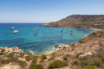 Beautiful azure blue water of Selmun beach in the summer time, in Maltese Imgiebah Bay, Il-Mellieha, Malta, June 2017