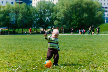 baby boy playing football at the stadium