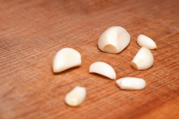 Obraz na płótnie Canvas Garlic cloves closeup on wooden Board
