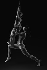 Young woman practicing aerial yoga hammock