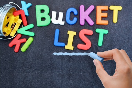 Young Woman Prepared For Bucket List With Metallic Bucket And Colorful Plastic Letters On Blackboard 