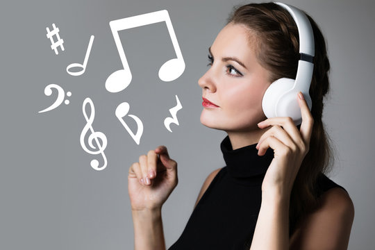 Young woman listening music with wireless headphones.