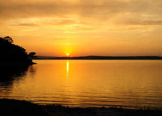 Fototapeta na wymiar Sunset scene on the lake with good tree silhouette