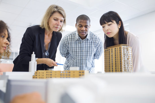 Architects looking at model in office