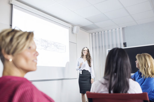 Female architect giving presentation at business meeting