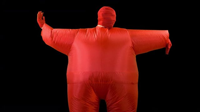 a man inside a red inflated fat suit dancingc