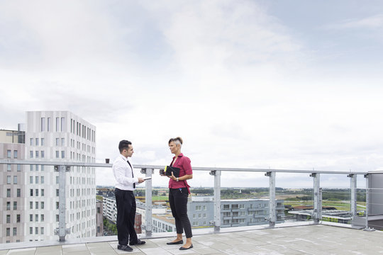 Business man and woman talking on rooftop
