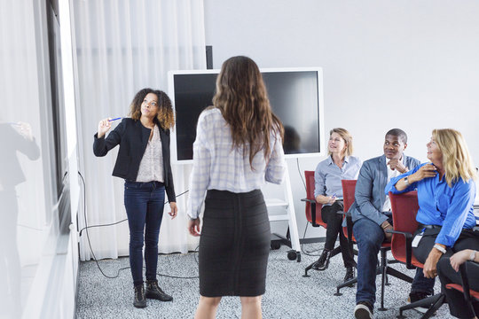 Female architects giving presentation at office meeting