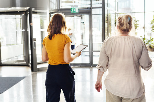 Two colleagues walking in office building lobby