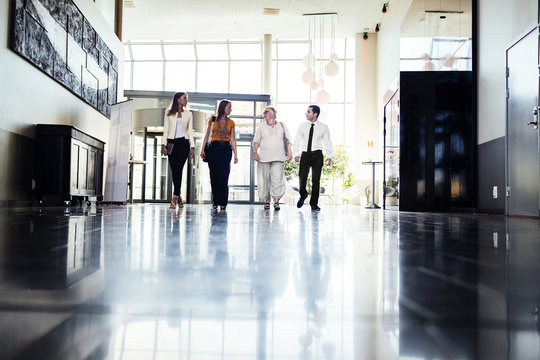 Four Colleagues Walking Through Lobby