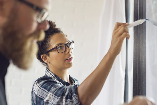 Office worker writing on glass wall
