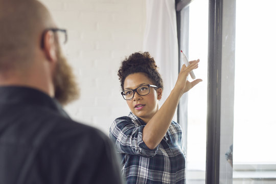 Office worker pointing at glass wall
