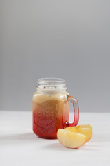 Fruit smoothie - healthy eating concept. Healthy smoothies with peach, apple and banana in a glass mason jar on a white background. Soft focus. Vegetarian food