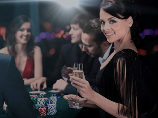 Poker players sitting around a table at a casino