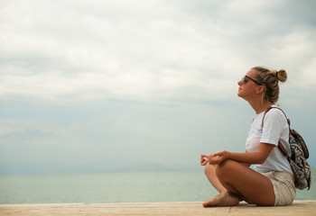 Happy young woman meditating at seacoast