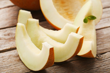 Slices of melons on grey wooden table
