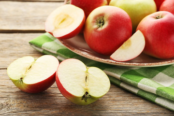 Ripe and sweet apples with napkin on grey wooden table