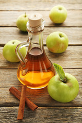 Apple vinegar in glass bottle on grey wooden table