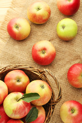 Ripe and sweet apples in basket on wooden table