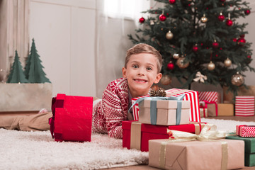 Obraz na płótnie Canvas boy laying on floor with christmas gifts