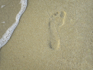 Fototapeta na wymiar impronta umana sulla spiaggia in riva al mare
