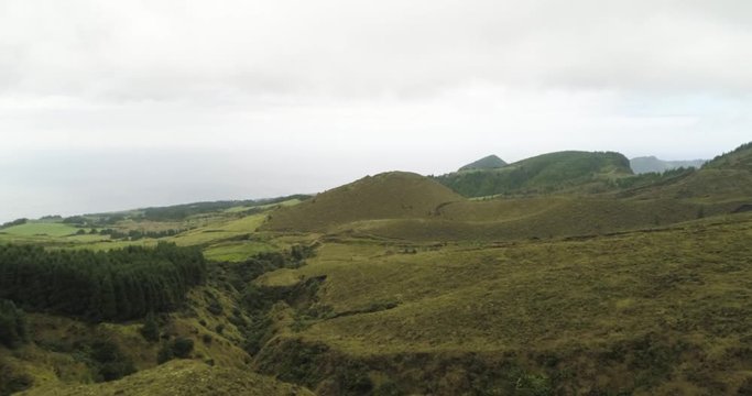 Aerial drone fly over lookalike hobbit green hills with misty clouds 