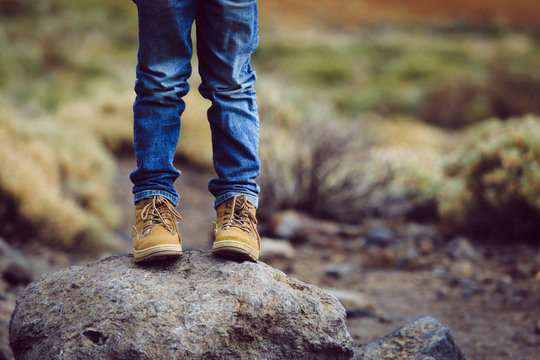 travel concept - little boy hiking boots in mountains