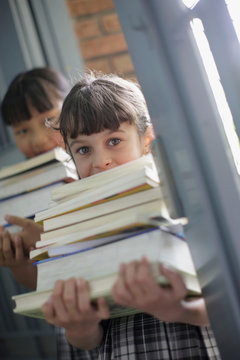 School girls holding stacks of books
