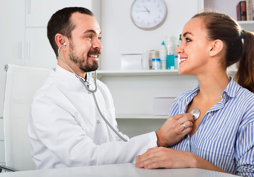 Female visitor consulting man doctor in hospital