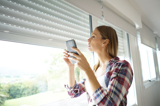 Woman using smartphone to control electric shutter