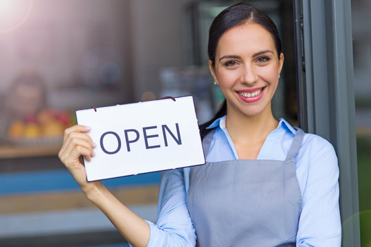 Woman holding open sign in cafe
- Powered by Adobe