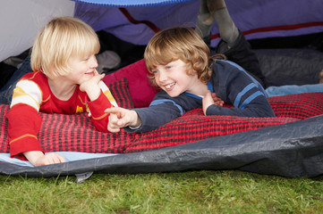 Two boys looking out of tent