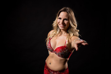 Fototapeta premium Beautiful belly dancer performing belly dance on black background.