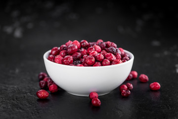Fresh made Dried Cranberries on a slate slab (close-up shot; selective focus)