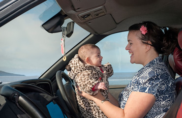 mother in car holding baby