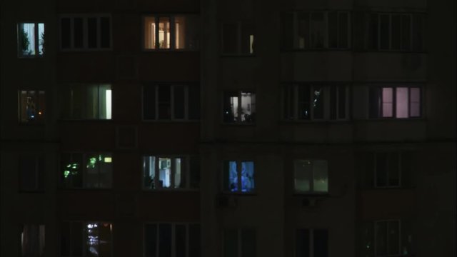 Timelaps of part of high rise with lights in windows at night