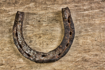 old rusty horseshoe on a wood background