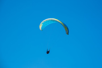 Yellow Paraglider over the Europe Alps mountains