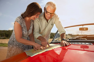 senior couple with car and map