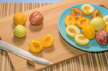 Summer fruits: apples, pears, apricots, plums on a blue plate